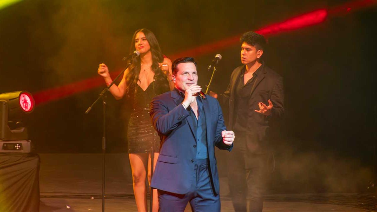 Cantante Daniel Boaventura interpretando baladas en vivo sobre el escenario del Forum Mundo Imperial en Acapulco, con luces de concierto y público disfrutando de su presentación musical.