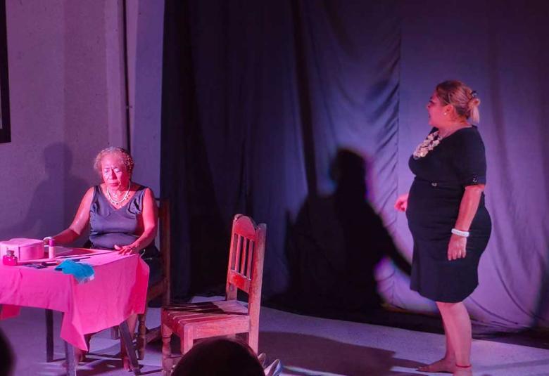Actriz de pie confronta a su madre sentada y afligida durante una escena de la obra Las Ubarry, presentada por la Compañía de Teatro Cámara Negra en Acapulco.