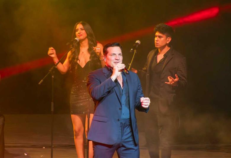Cantante Daniel Boaventura interpretando baladas en vivo sobre el escenario del Forum Mundo Imperial en Acapulco, con luces de concierto y público disfrutando de su presentación musical.